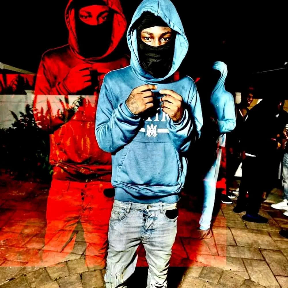  壁紙 — 一個穿著藍色連帽衫和黑色口罩的人夜晚站在瓷磚路面上，身後有一個帶紅色調的鬼影。