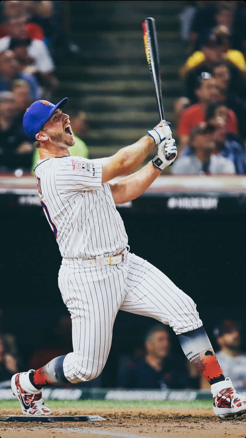Pete Alonso 擊出震撼全壘打 壁紙 — 一名身穿細條紋球衣的棒球手在球場燈光下的夜間比賽中，專注地揮棒。