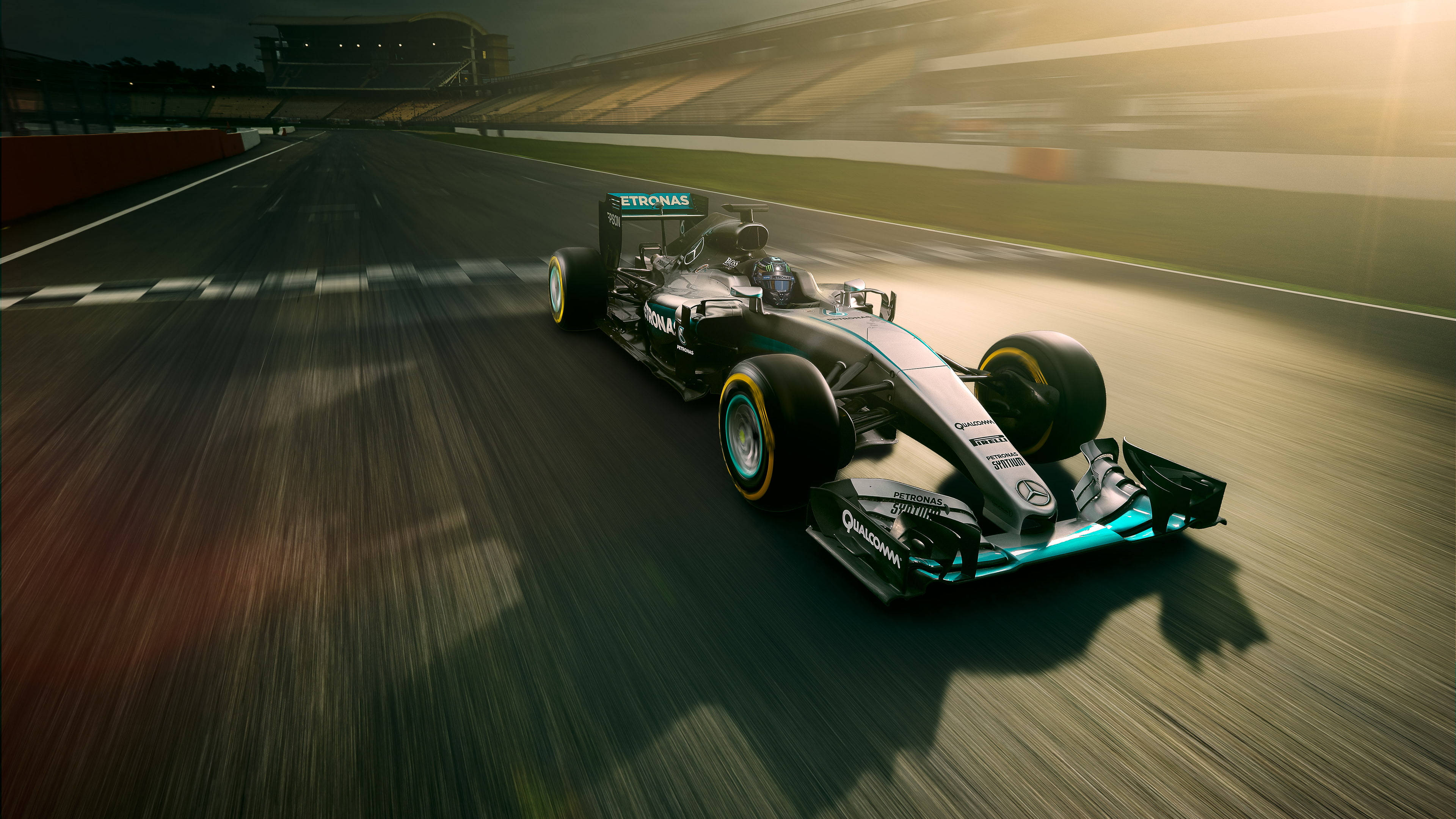 Petronas F1高速攝影 壁紙 — 一輛時尚的銀色和藍綠色一級方程式賽車在金色夕陽下疾馳，帶有動態模糊效果。