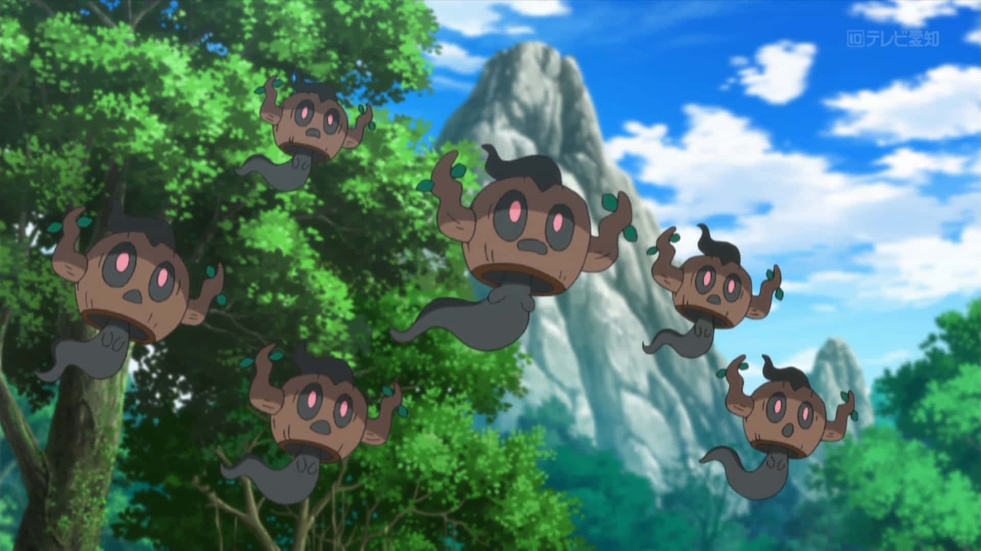 Phantump 克隆體漂浮 壁紙 — 數個漂浮的鬼魂般寶可夢，有著粉紅色眼睛，在茂密的綠樹間飄浮，背景是明亮的藍天白雲。