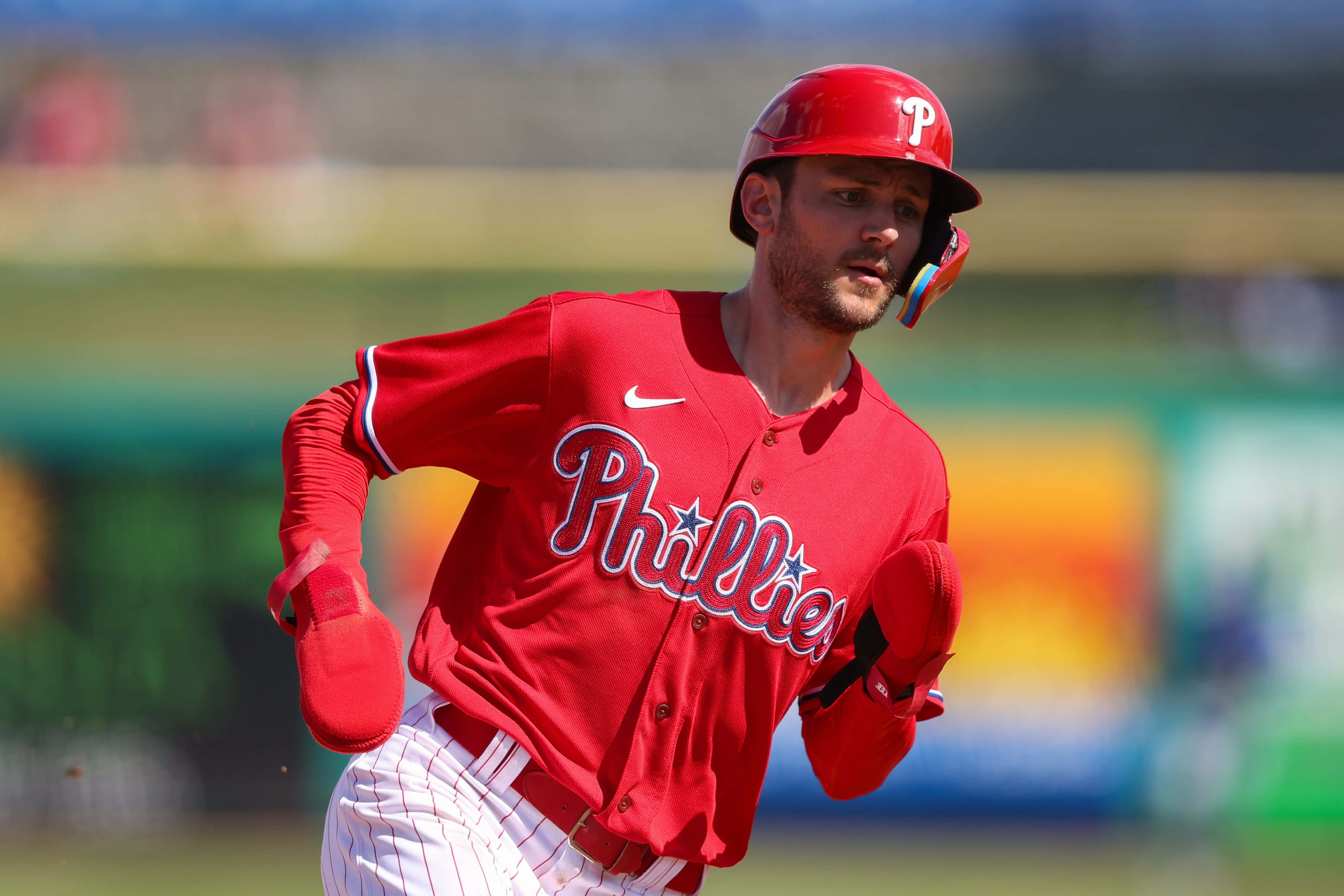 Trea Turner Phillies 桌布 壁紙 — 一名身穿紅色球衣的費城費城人棒球運動員在陽光明媚的球場上全神貫注地衝刺。