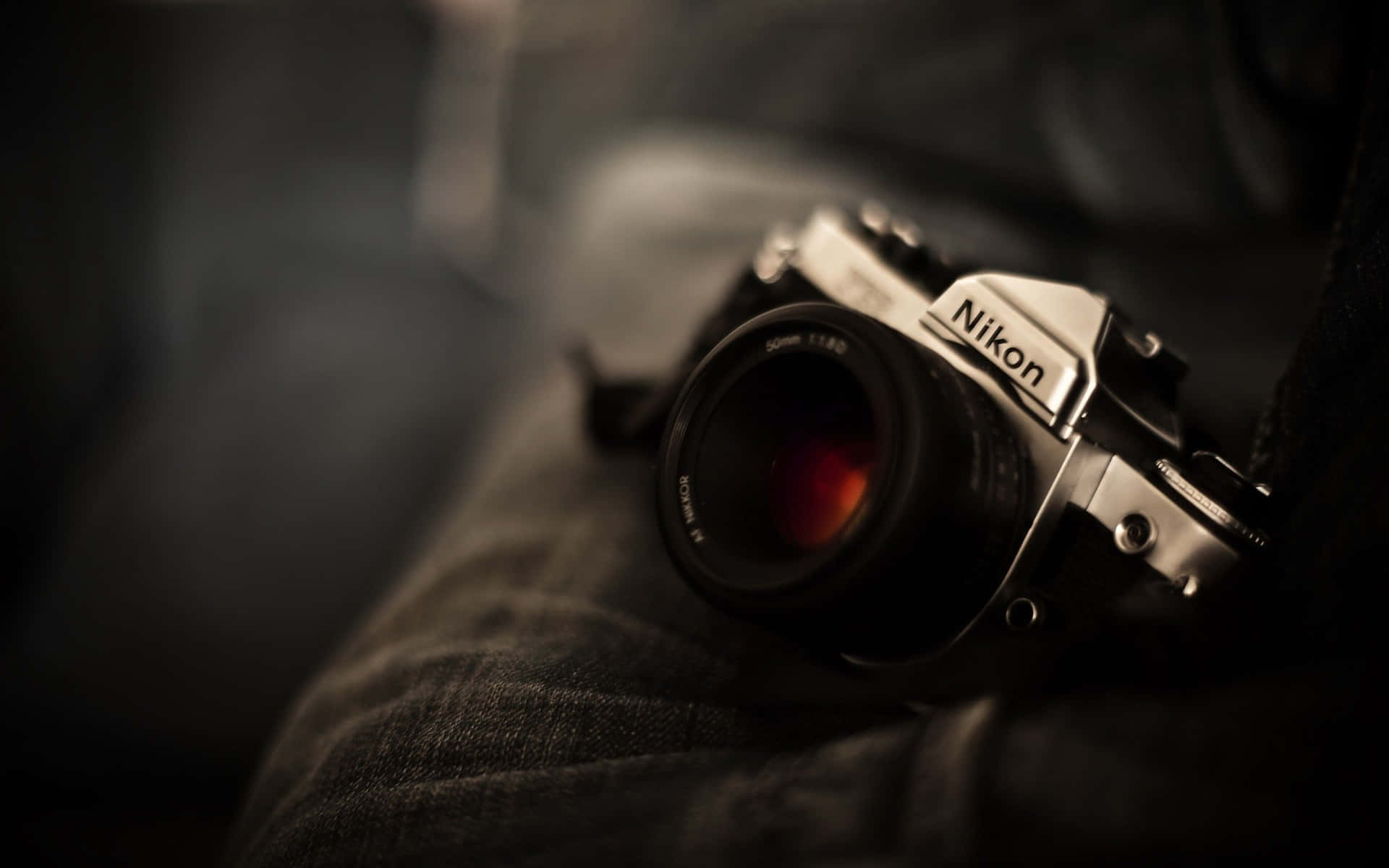 復古 Nikon 菲林相機在昏暗光線下放置在牛仔布上。