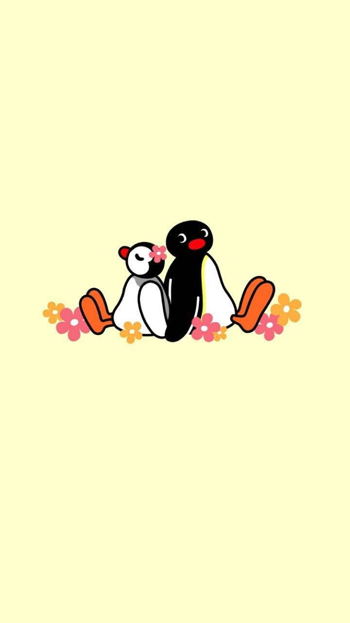 Pingu 與 Pinga 與花朵 壁紙 — 兩隻可愛的卡通企鵝一起坐在柔軟的黃色背景上，周圍是色彩繽紛的花朵。