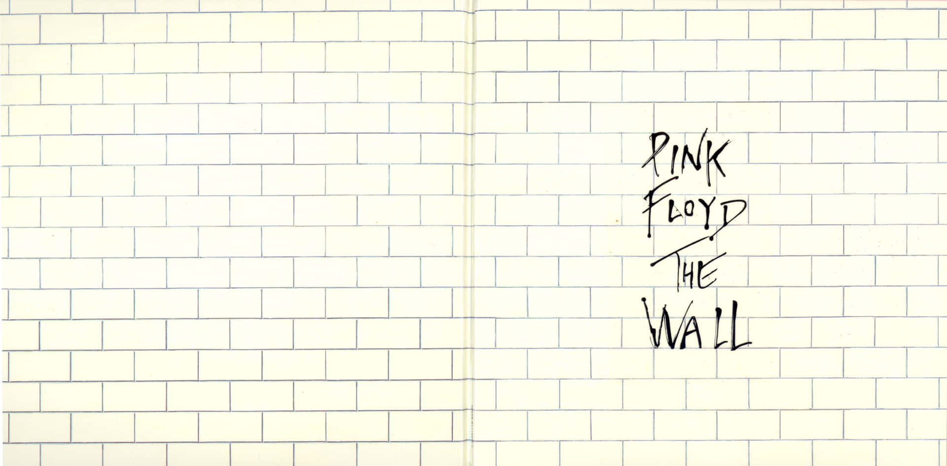 在奶油色磚牆上以黑色墨水寫成的Pink Floyd The Wall。