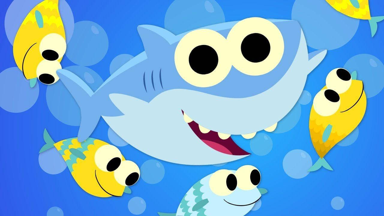 一隻微笑的卡通鯊魚在水下被黃色魚和氣泡包圍。