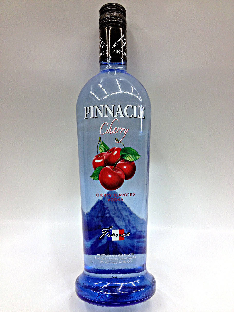 藍色樽的Pinnacle Cherry伏特加，帶有櫻桃插圖和山脈設計。