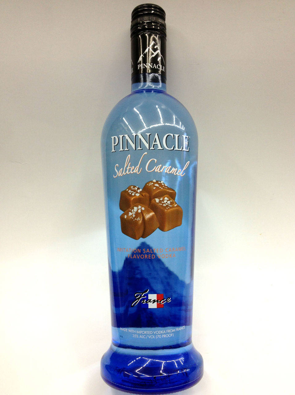 藍色Pinnacle鹹焦糖伏特加酒瓶，標籤上有焦糖糖果圖案。