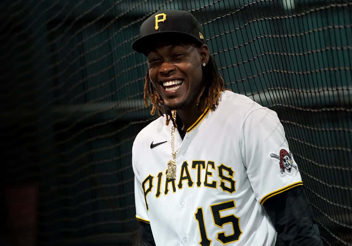  壁紙 — 一位身穿 Pirates 球衣的棒球手在背後有網的擊球籠中開懷大笑。