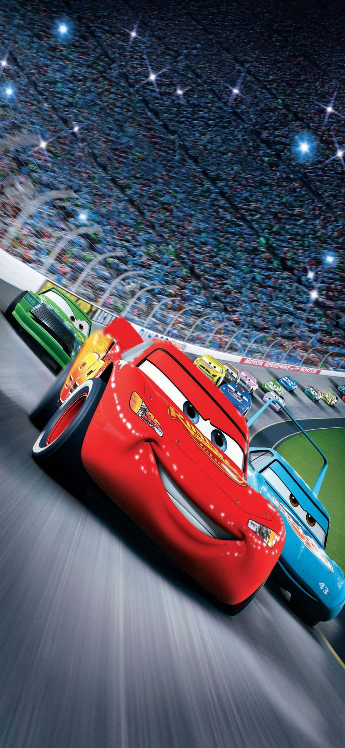 Piston Cup 麥昆 iPhone X 賽車壁紙 壁紙 — 紅色動畫賽車閃電麥坤在星光燦爛的夜空下，在燈火通明的賽道上超越對手。