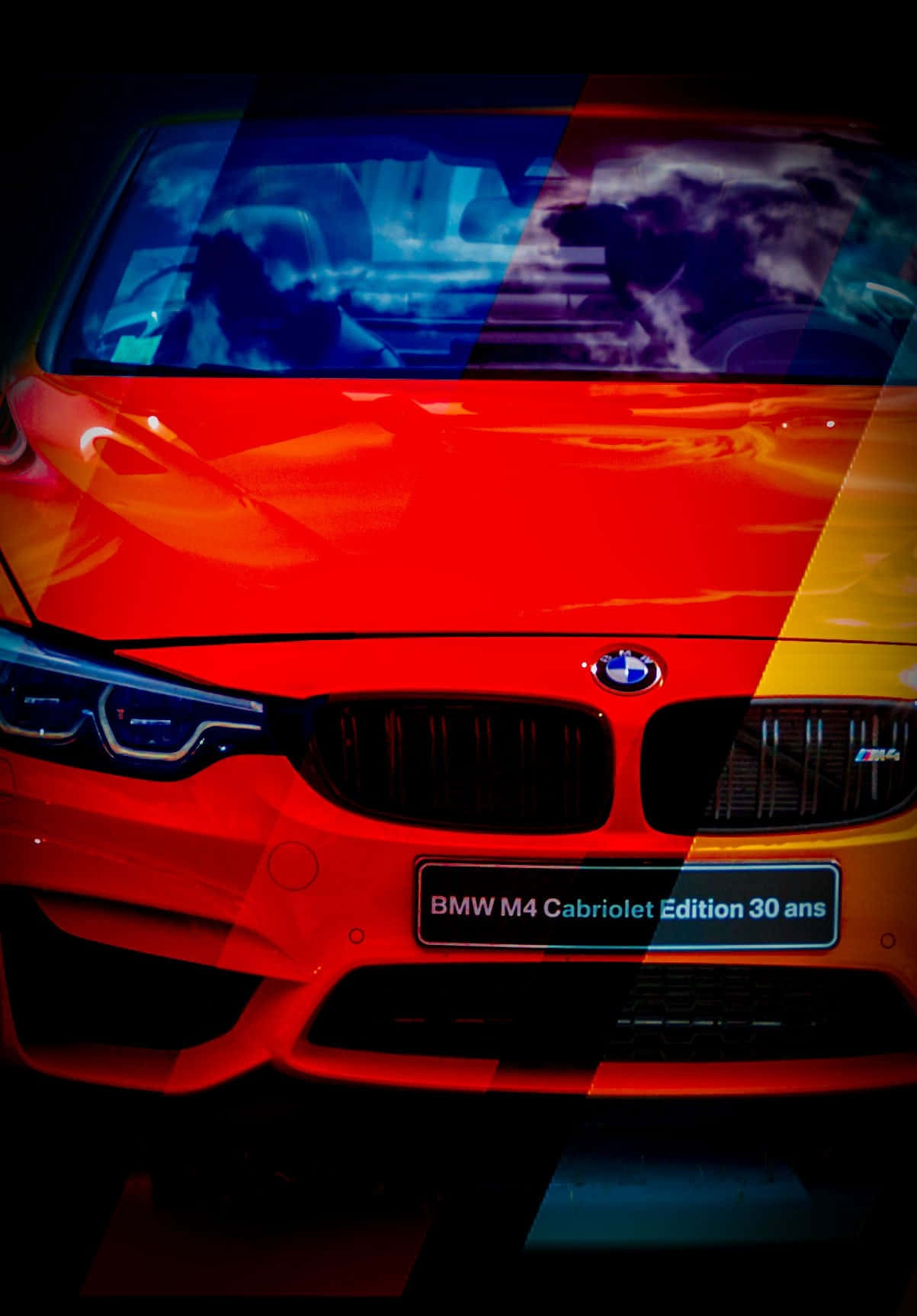 帶有彩色抽象覆蓋層和戲劇性燈光的紅色BMW M4 Cabriolet Edition 30 ans。