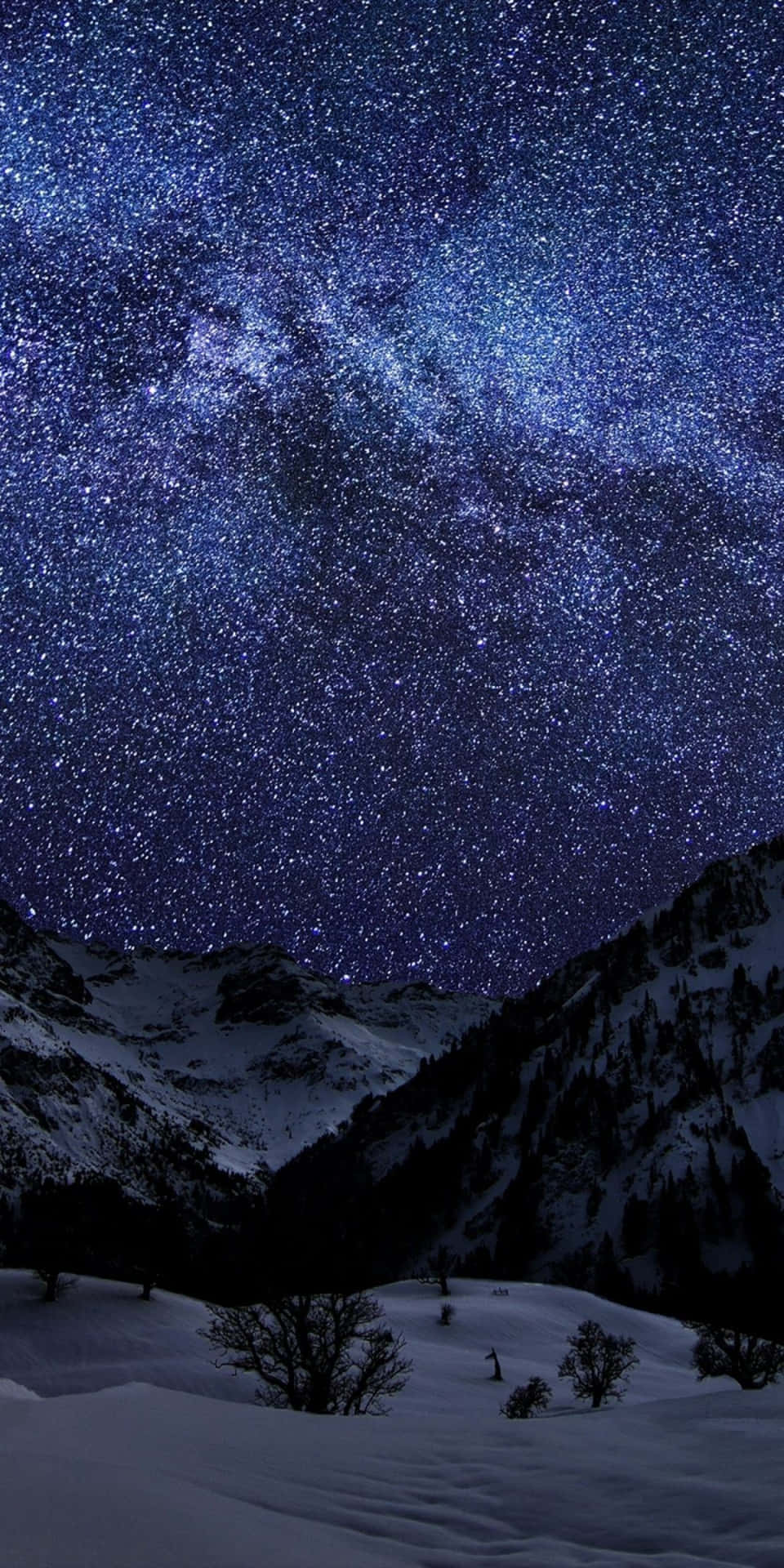 在繁星點點的夜空下，積雪的山峰和可見的銀河。