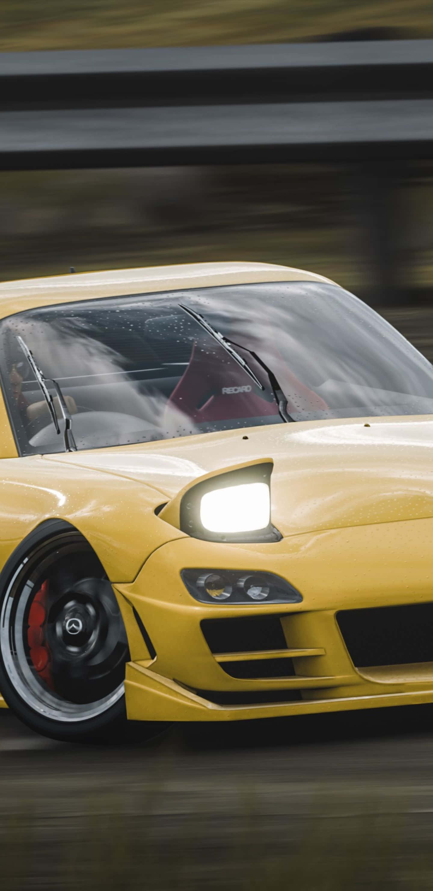 Pixel 3XL 上《Forza Horizon 4》的驚人圖像體驗 壁紙 — 一輛鮮黃色跑車在潮濕道路上高速前進，帶有動態模糊效果，車頭燈明亮發光。