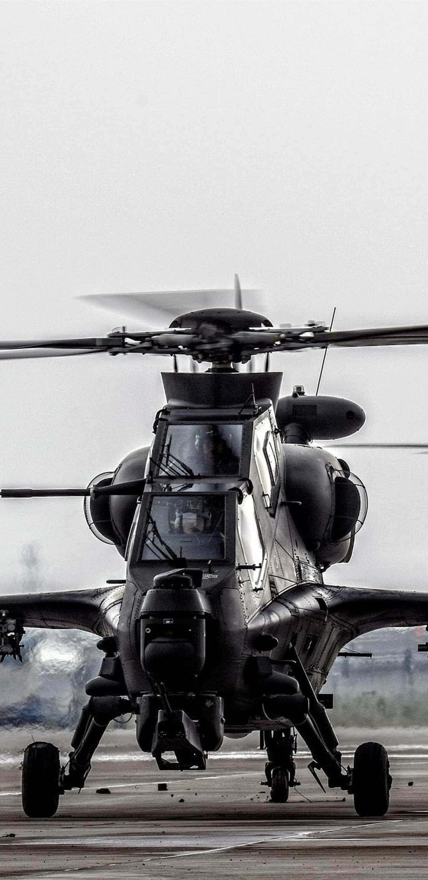 Pixel 3XL 背景：CAIC Z-10 直升機 壁紙 — 一架軍用直升機帶旋轉槳葉停在跑道上，天空多雲，單色調。