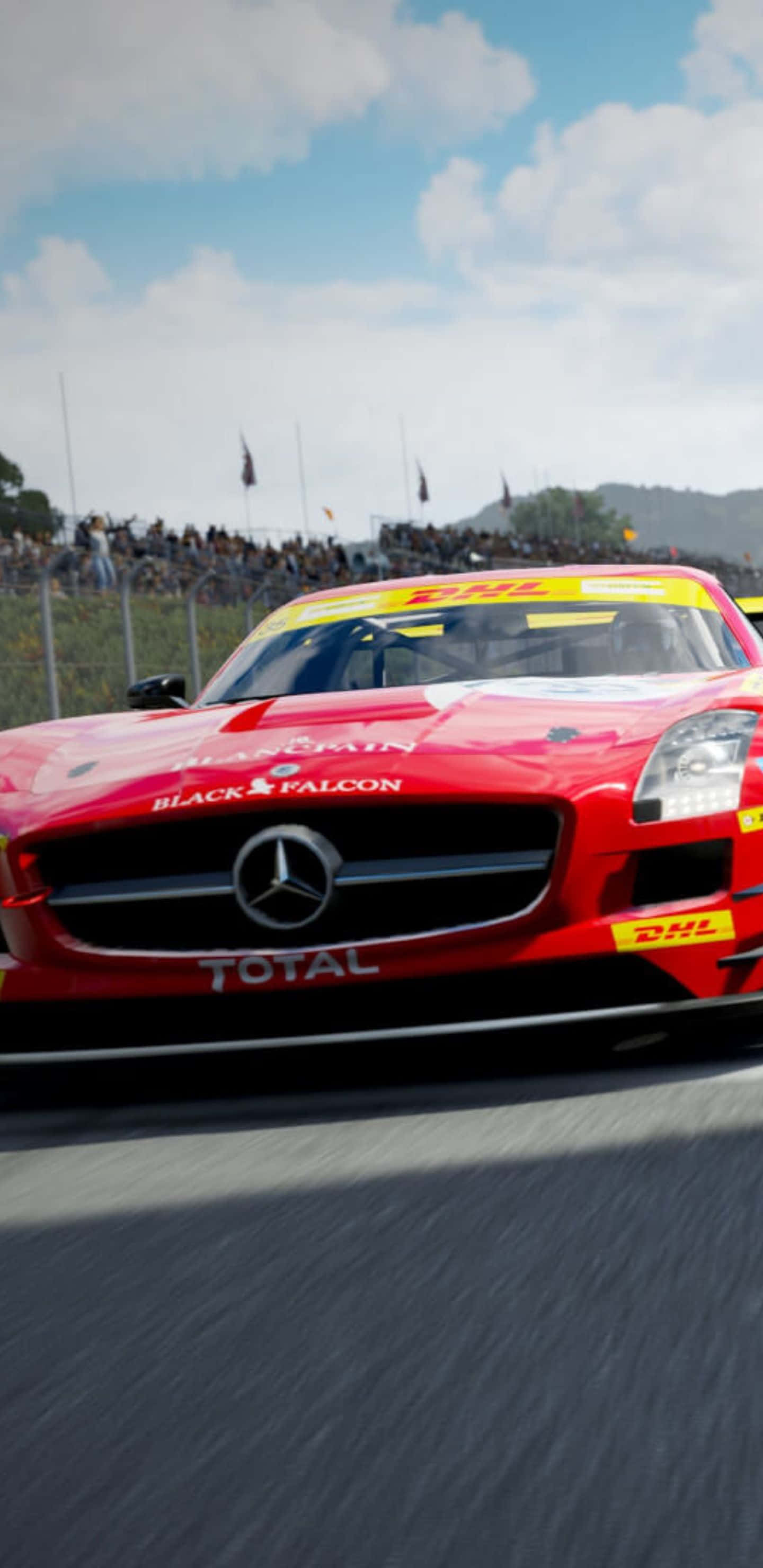 Pixel 3XL 與 Forza Motorsport 7 的加速競速 壁紙 — 一架紅色 Mercedes-AMG GT3 賽車在賽道上飛馳，背景有觀眾，天空部分多雲。
