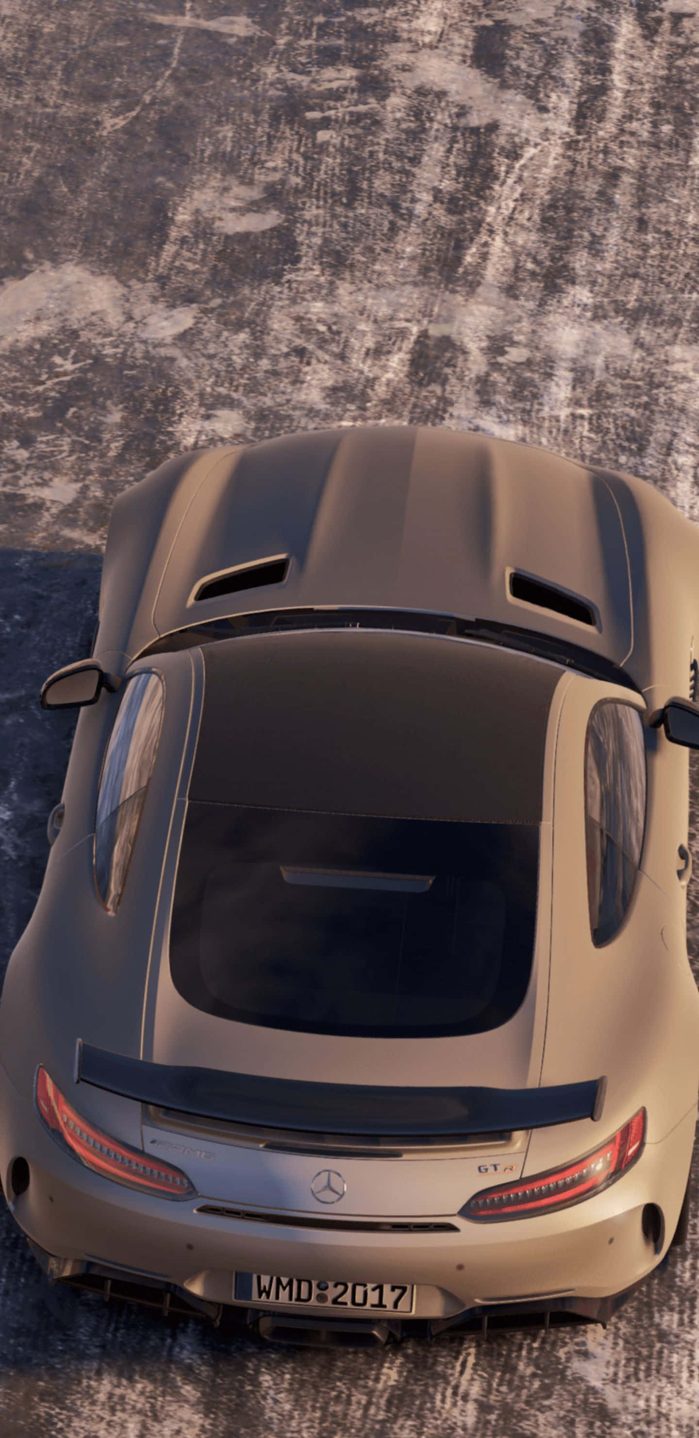 Pixel 3XL上《Project Cars 2》的震撼賽車體驗 壁紙 — 一輛啞光灰色的梅賽德斯-AMG GT R 跑車從上方俯視，位於裂縫的瀝青路面上，沐浴在溫暖的陽光下。