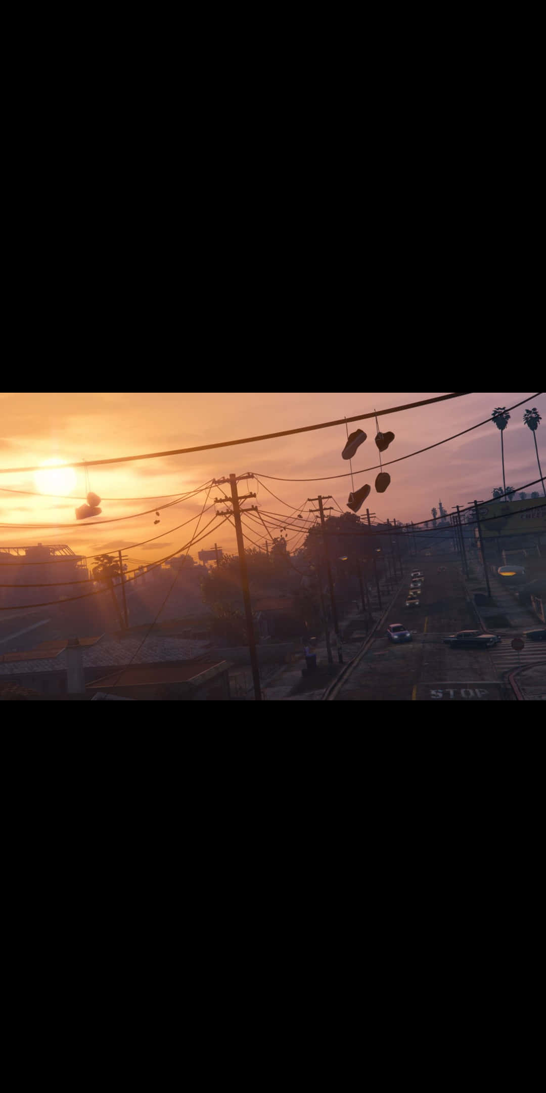 Pixel 3上的《GTA V》壯觀壁紙 壁紙 — 夕陽在都市街道上投射出溫暖的橙色光芒，鞋掛在電線上，下方停著汽車。