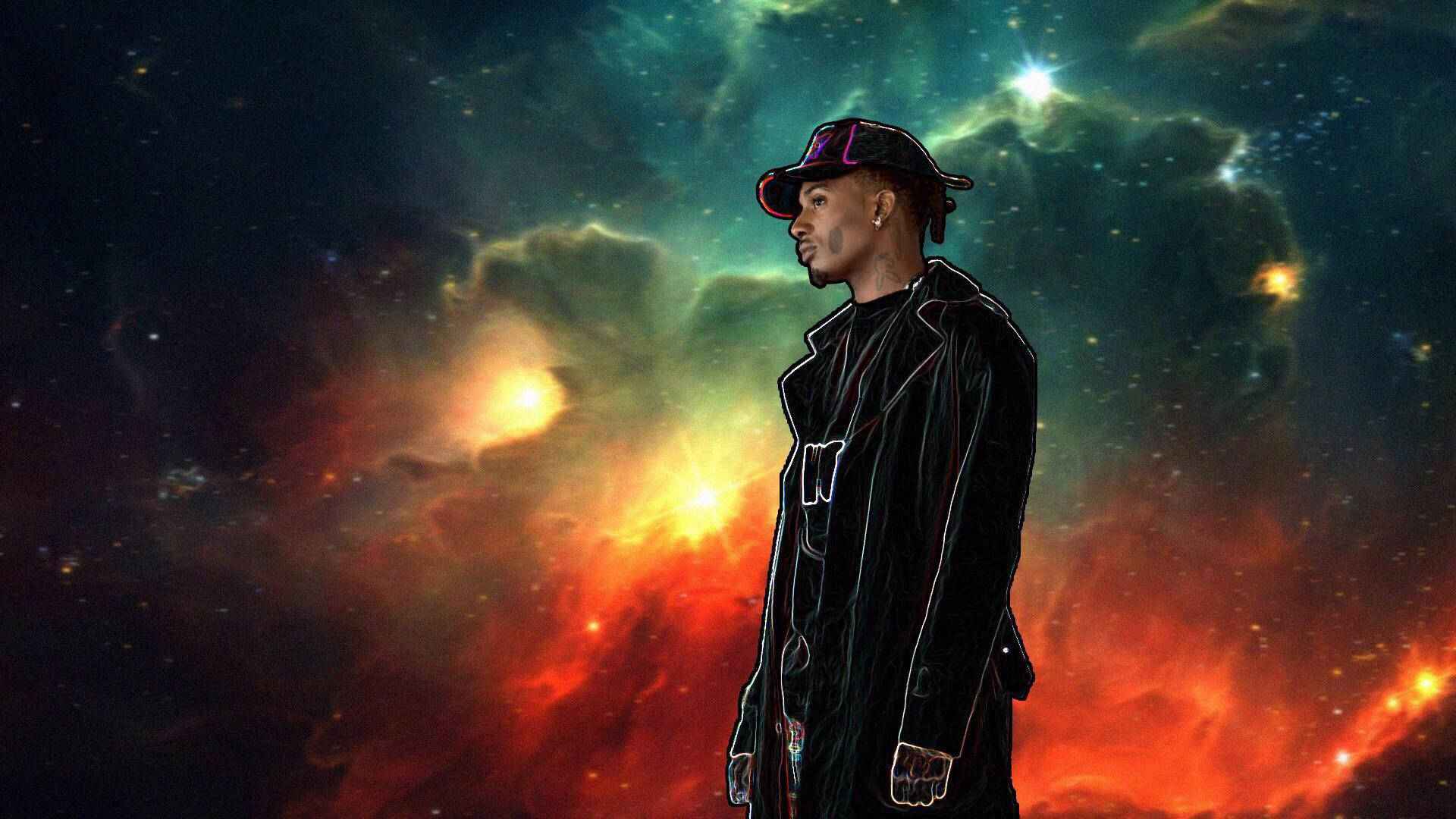 Playboi Carti PFP 星空版 壁紙 — 一個穿著黑色外套和帽子的時尚男子站在充滿活力的宇宙星雲前，星雲中有旋轉的紅色、橙色和藍綠色雲彩。