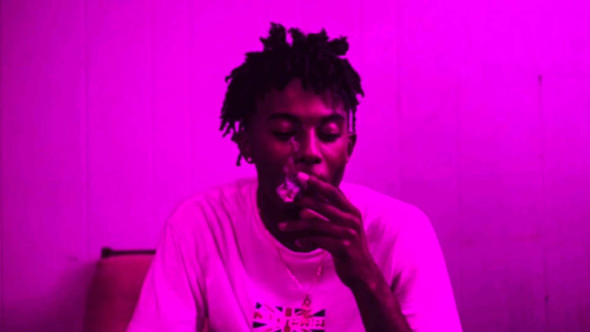 在室內洋紅色燈光下吸電子煙的人