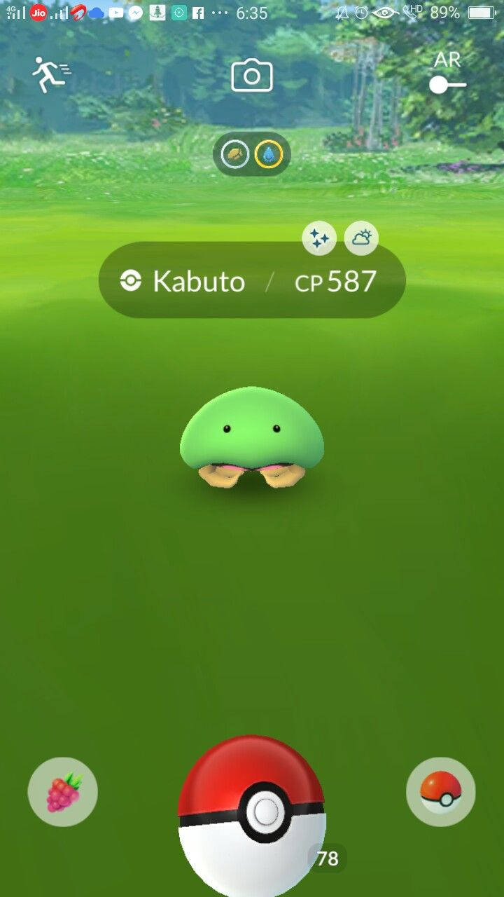 一隻綠色的 Kabuto 寶可夢在 Pokémon GO 遊戲介面中的草地上。