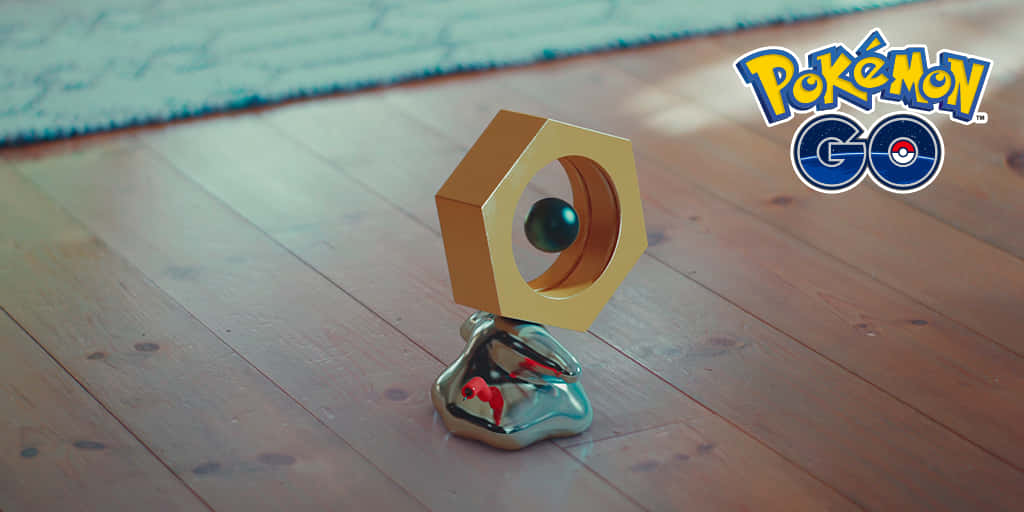 Pokémon Go中的野生Meltan 壁紙 — 一個金色六角精靈球放在閃亮的銀色底座上，置於木地板，背景有藍色地毯。
