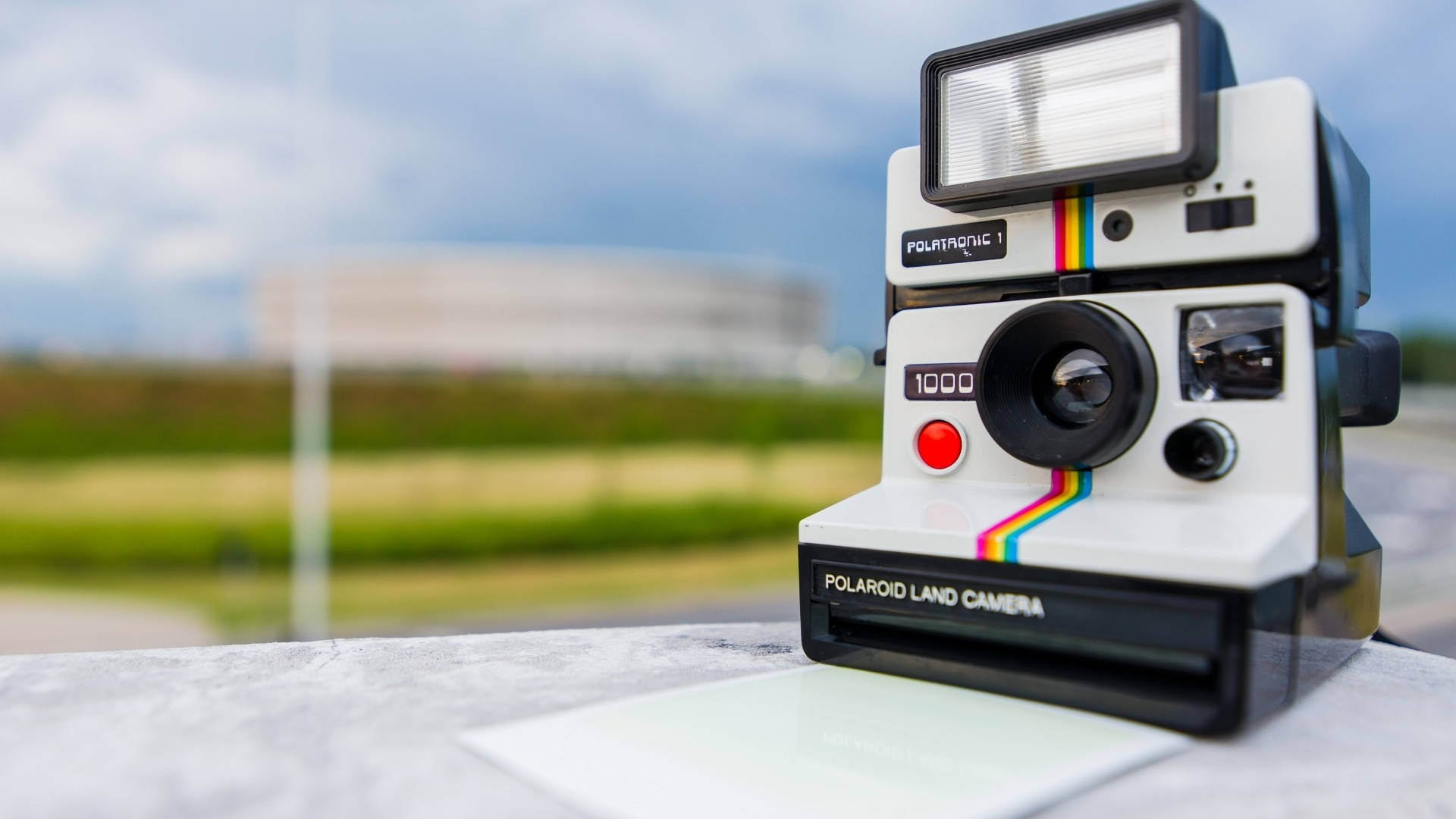 一部復古Polaroid Land Camera 1000相機在石頭表面上，背景模糊的戶外景色。