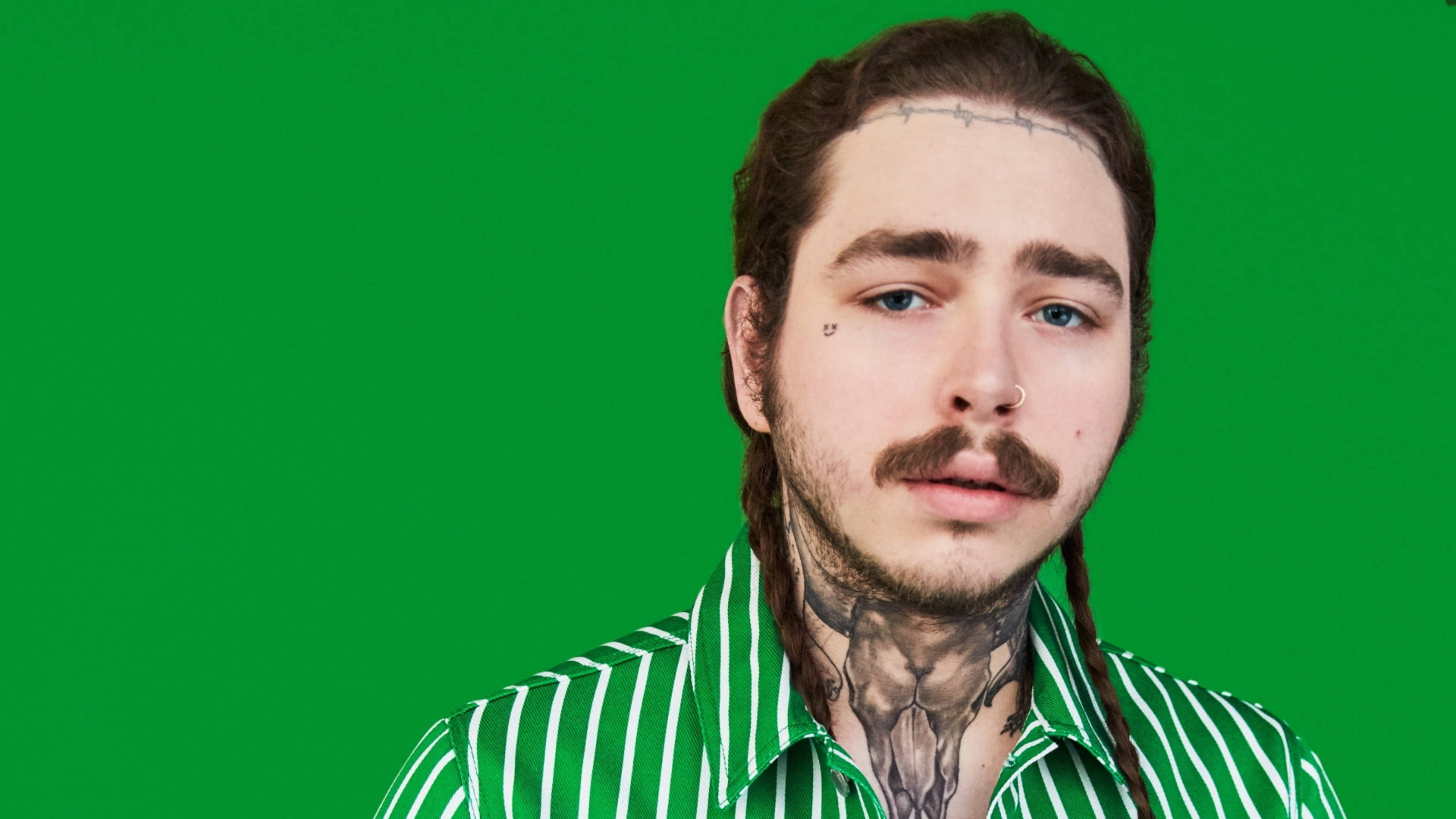 Post Malone《GQ》2018年1月封面 壁紙 — 一個有辮子頭髮和頸部紋身的男人直視鏡頭，背景是純綠色。
