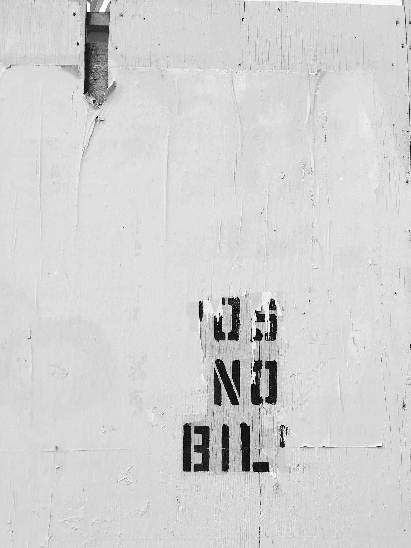 剝落的白色牆壁，粗體黑色模板文字寫著 no bills