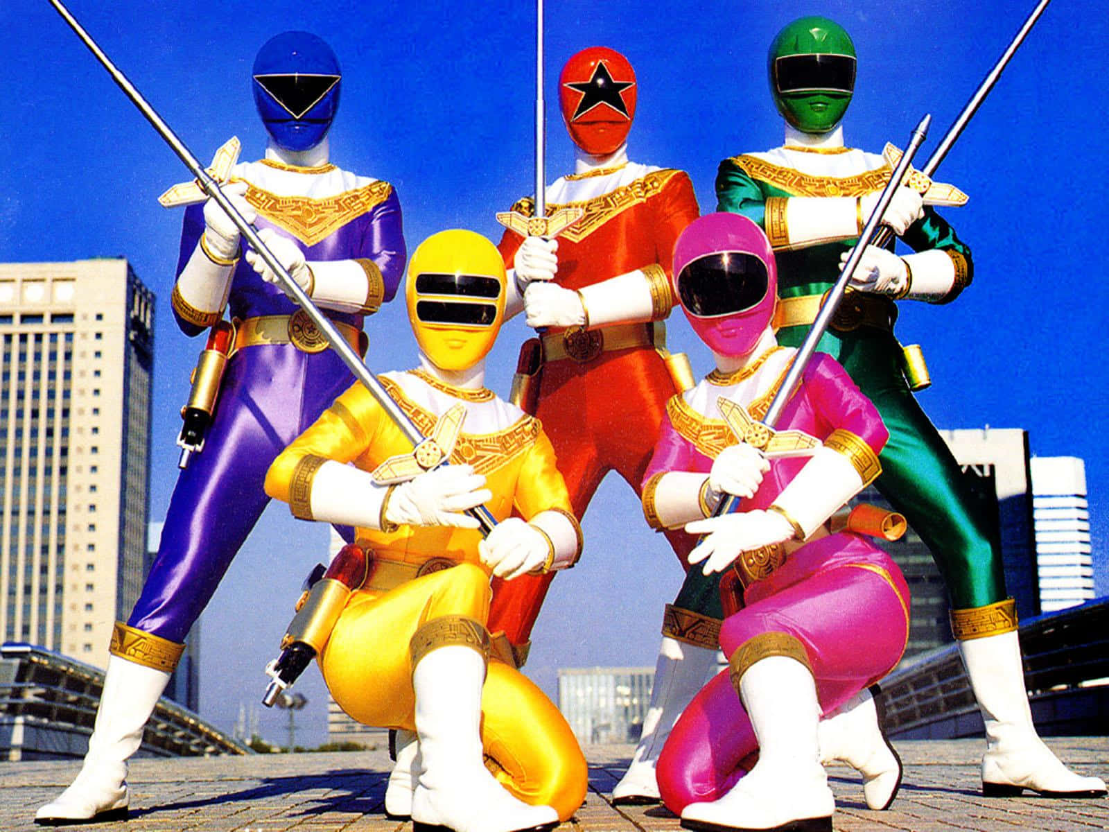 「Power Rangers現身保護我們！」 壁紙 — 五位身穿色彩繽紛服裝的電力戰士，在明亮的藍天和城市天際線背景下，手持劍擺出英勇姿勢。