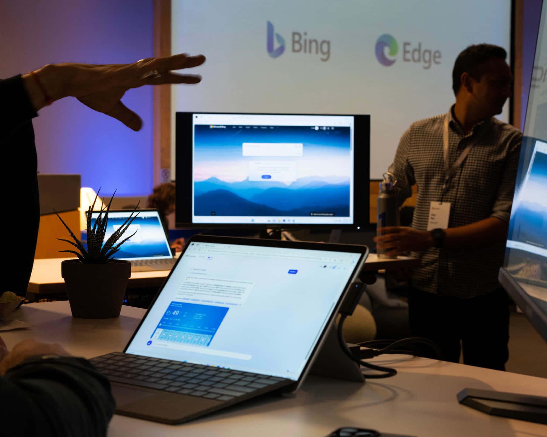 科技演講者在會議上向顯示 Bing 和 Edge 的筆記型電腦做手勢。