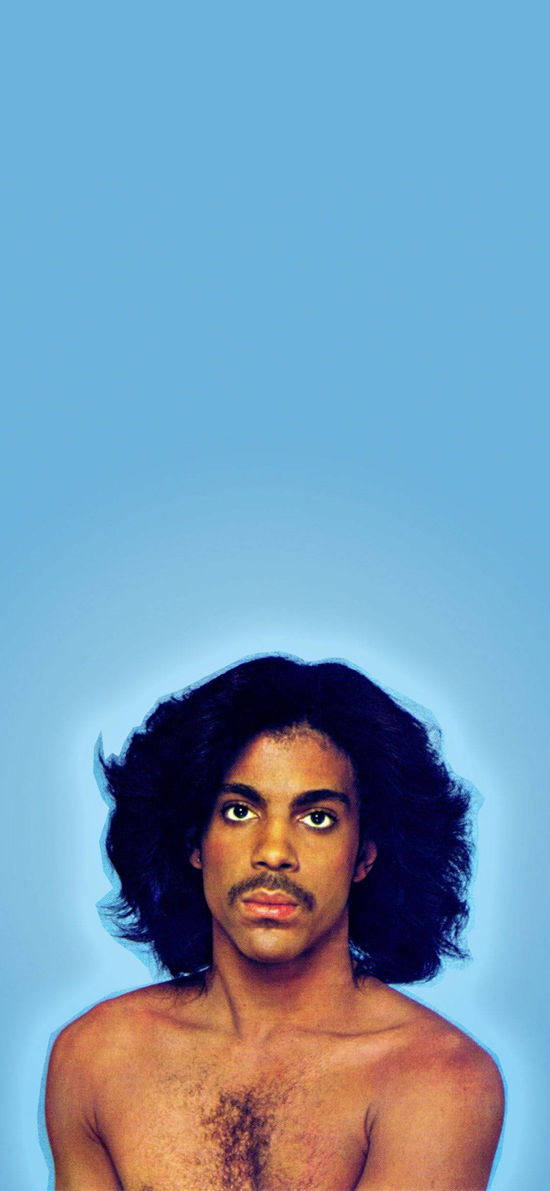Prince 最簡藍色 壁紙 — 一個赤膊、捲髮、留鬍子的男人在純藍色背景下直視鏡頭。