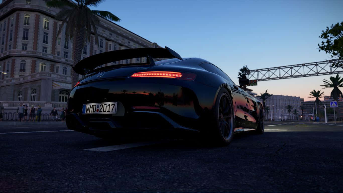 Project Cars 2 梅賽德斯-AMG GT 背景 壁紙 — 一輛時尚黑色跑車，帶有發光的紅色尾燈，停泊在黃昏的城市街道上，背景有棕櫚樹和一座宏偉建築。
