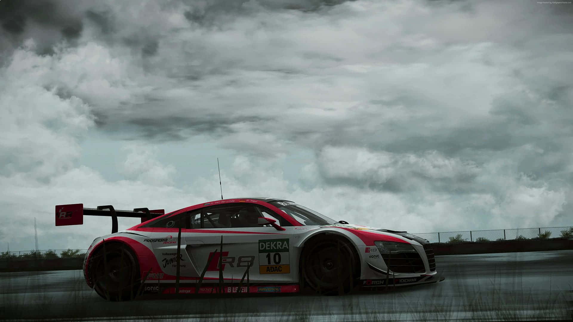 Project Cars 2016 年款 Audi R8 LMS 高清背景 壁紙 — 一輛紅白相間、編號10的賽車在戲劇性的多雲天空下，在潮濕的賽道上疾馳。