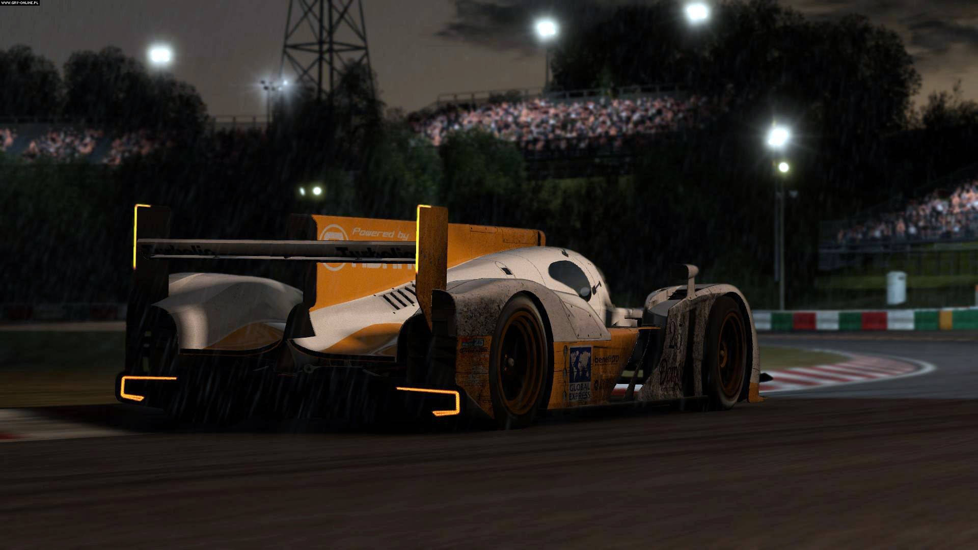 Project Cars 4K 黃色一級方程式賽車 壁紙 — 一輛流線型的橙色和白色賽車在明亮的泛光燈下，在雨濕的夜間賽道上飛馳，看台上觀眾歡呼。