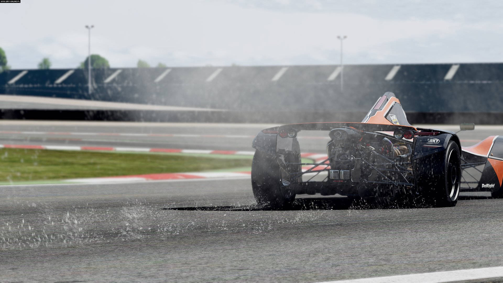 Project Cars 4K 一級方程式賽車 壁紙 — 一輛黑色和橙色的賽車在陰天潮濕的賽道上濺起水花穿過水坑。