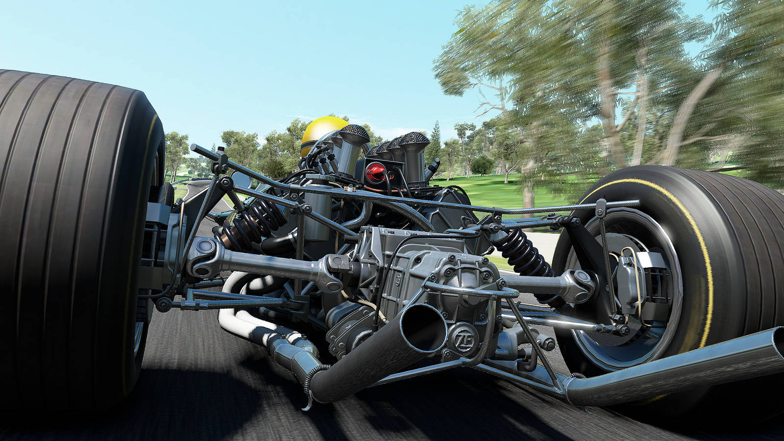 Project Cars 4K 一級方程式引擎特寫 壁紙 — 低角度拍攝一輛未來賽車的裸露底盤，在陽光普照的公園中疾馳，背景是模糊的綠植。