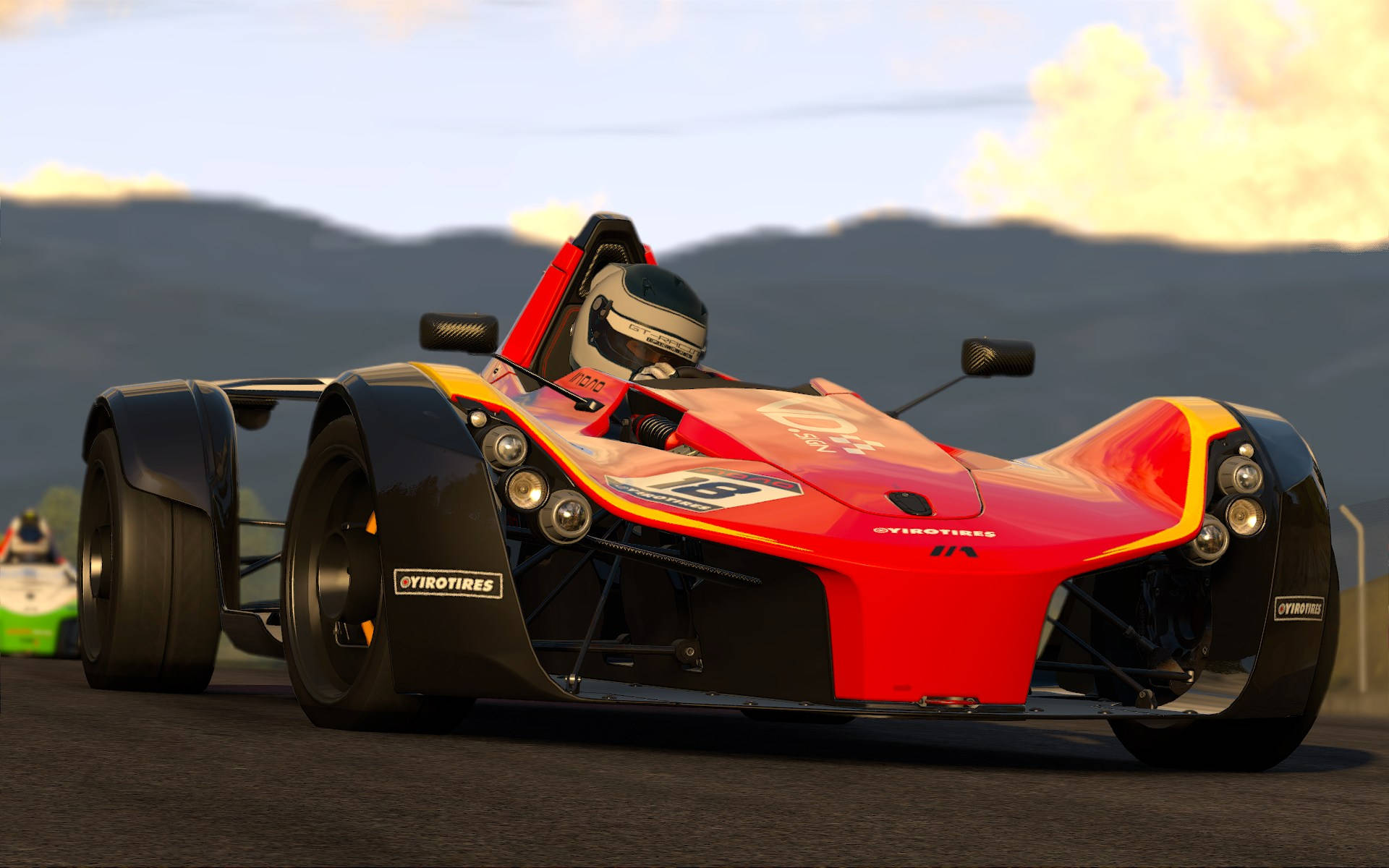 Project Cars 4K 紅色一級方程式賽車 壁紙 — 一輛紅黑配色的開輪式賽車在日落時分沿著賽道飛馳，背景是山脈。