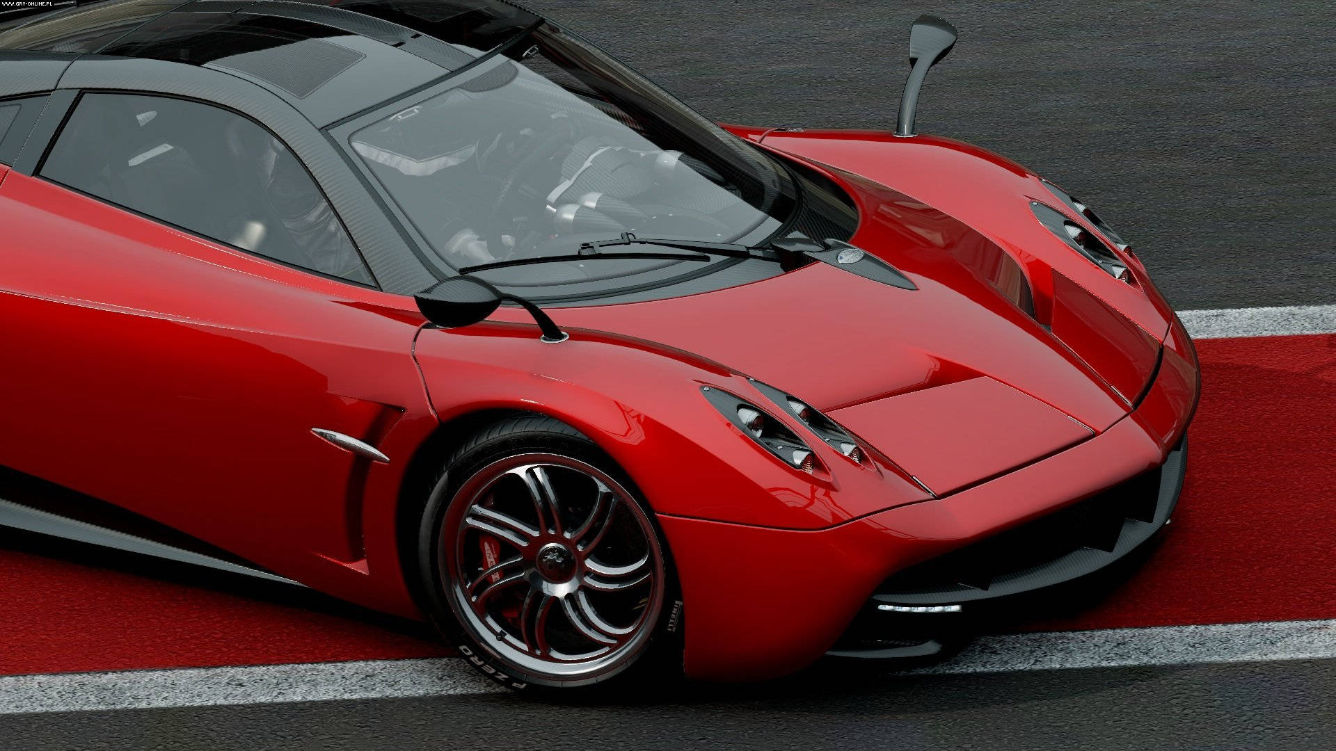 Project Cars 4K 紅色帕加尼 Huayra 壁紙 — 一架光澤紅色Pagani Huayra跑車停泊在設有白色和紅色路緣石的賽道上。