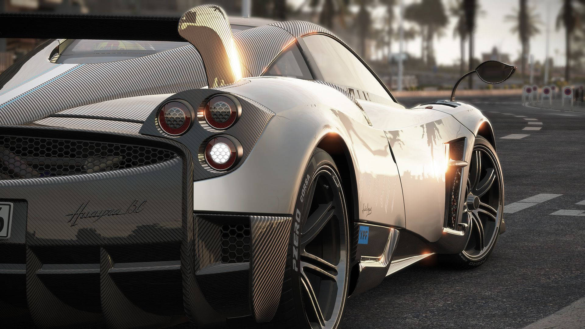 Project Cars 4K Pagani Huayra BC 壁紙 — 一輛銀色Pagani Zonda Cinque跑車在日落時分的賽道上閃閃發光，背景有棕櫚樹。