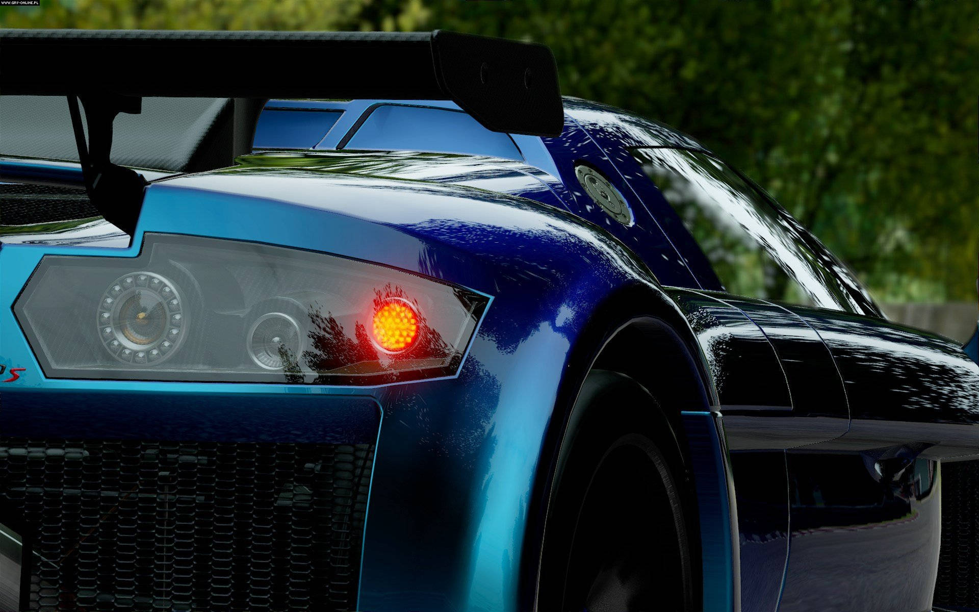 Project Cars 4K 金屬藍色阿波羅 壁紙 — 一輛時尚藍色跑車的橙色轉向燈特寫，背景是模糊的綠色樹葉。