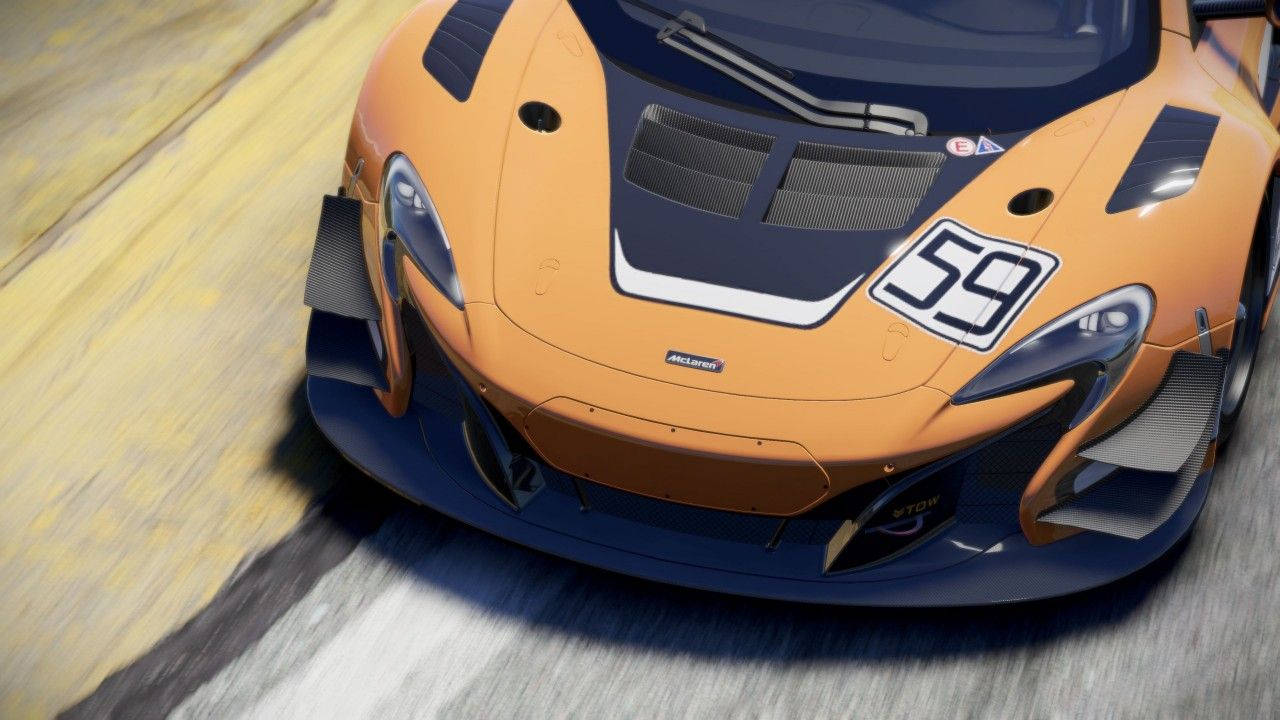 Project Cars 4K 麥拉倫前保險桿 壁紙 — 一輛高速的橙色和藍色59號賽車在賽道上以動態低角度鏡頭呼嘯而過。