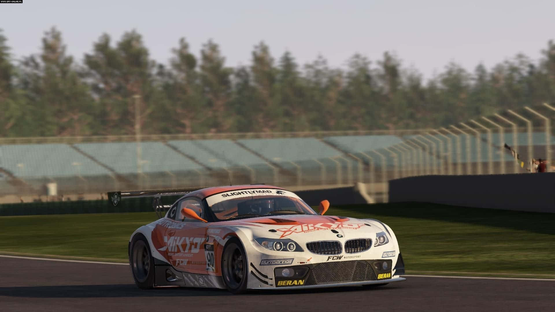 Project Cars BMW Z4 Gt3 模型高清背景 壁紙 — 一架白色和橙色嘅BMW賽車（號碼59）喺賽道上飛馳，背景有綠色草地同空嘅看台。