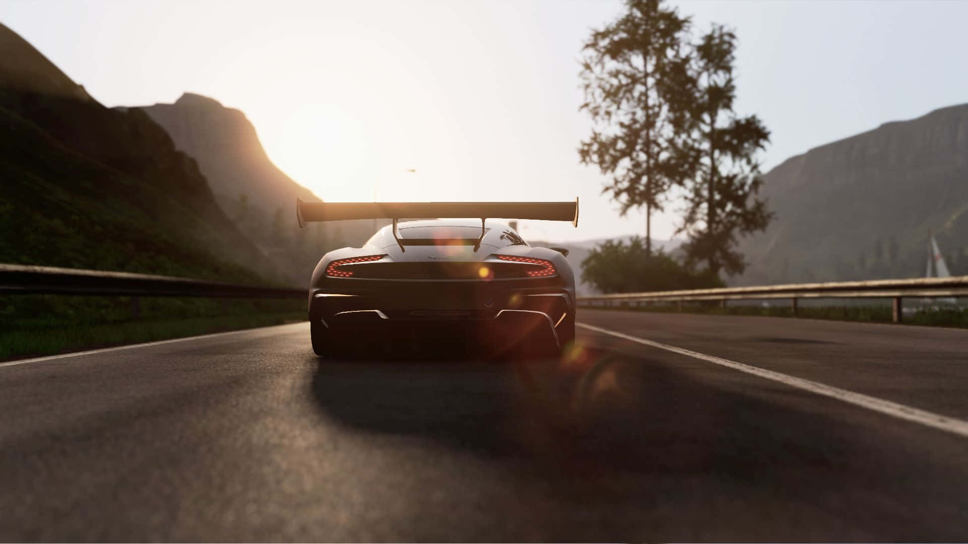 Project Cars — 挑戰世界冠軍，駕馭勝利 壁紙 — 一輛時尚的黑色跑車配備大型後擾流板，在日落時分沿著山路駛離，散發出溫暖的光芒。