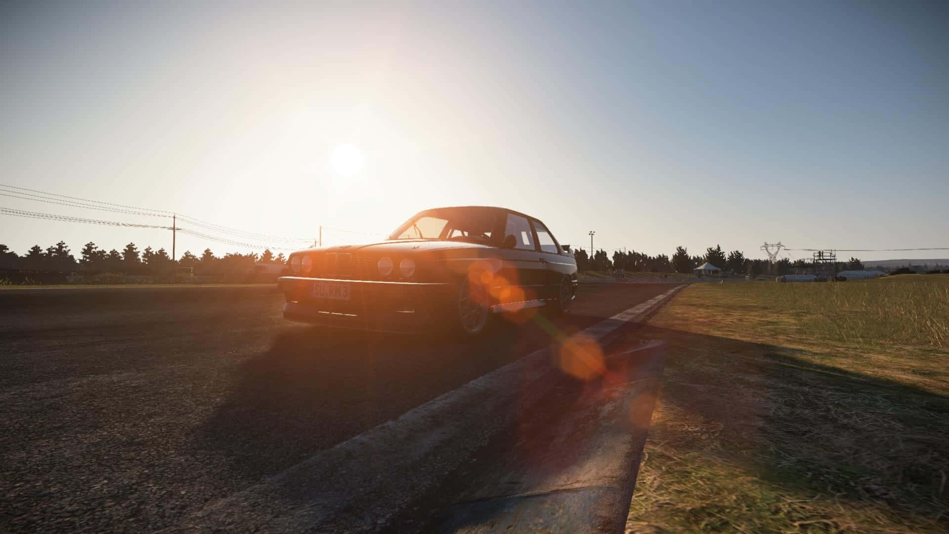 Project Cars 日光灑落賽車高清背景 壁紙 — 一輛經典汽車沿著鄉村道路行駛，沐浴在金色的日落光線中，鏡頭光暈在瀝青上舞動。
