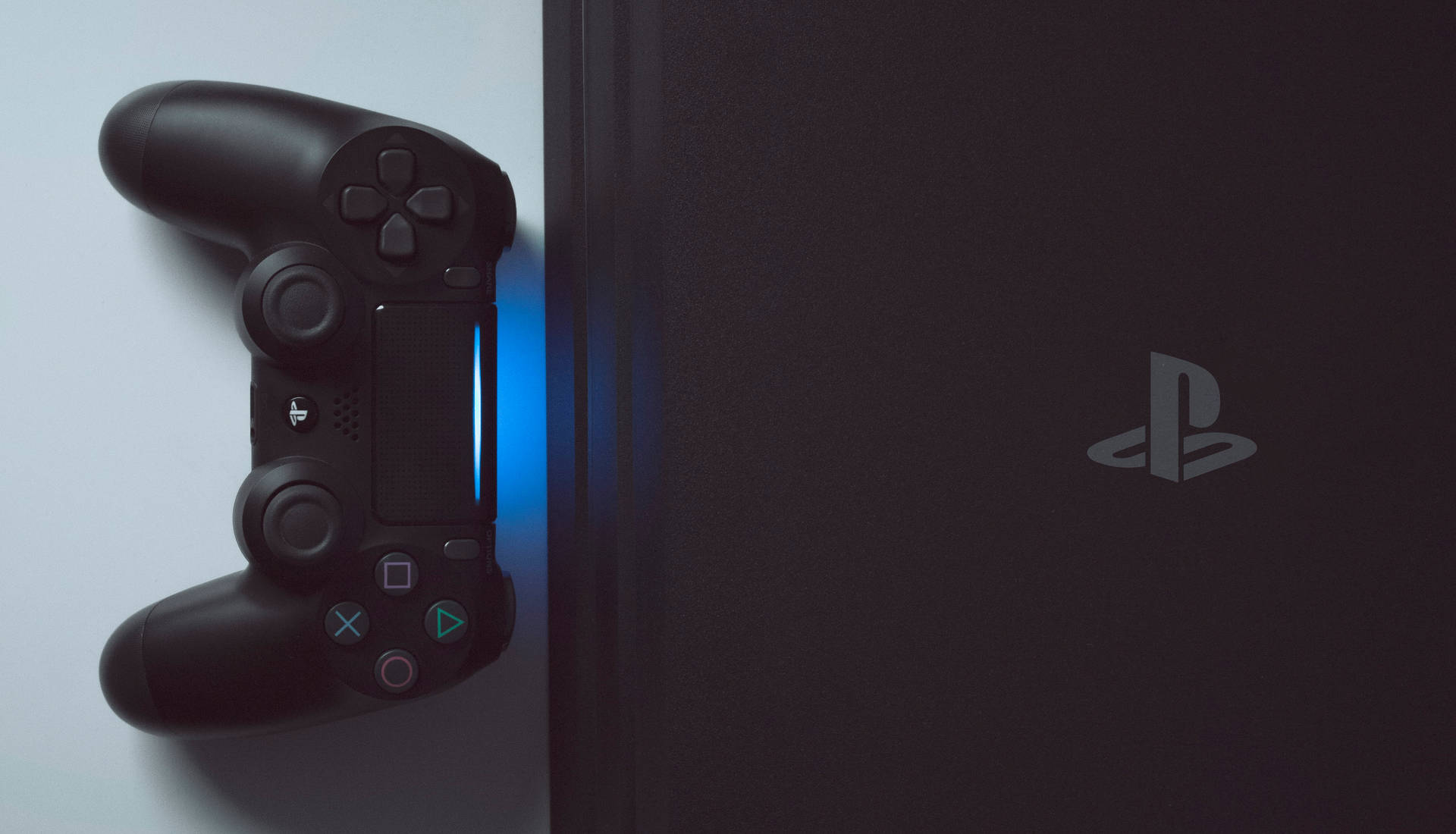 黑色PlayStation手掣旁邊的遊戲機發出藍光