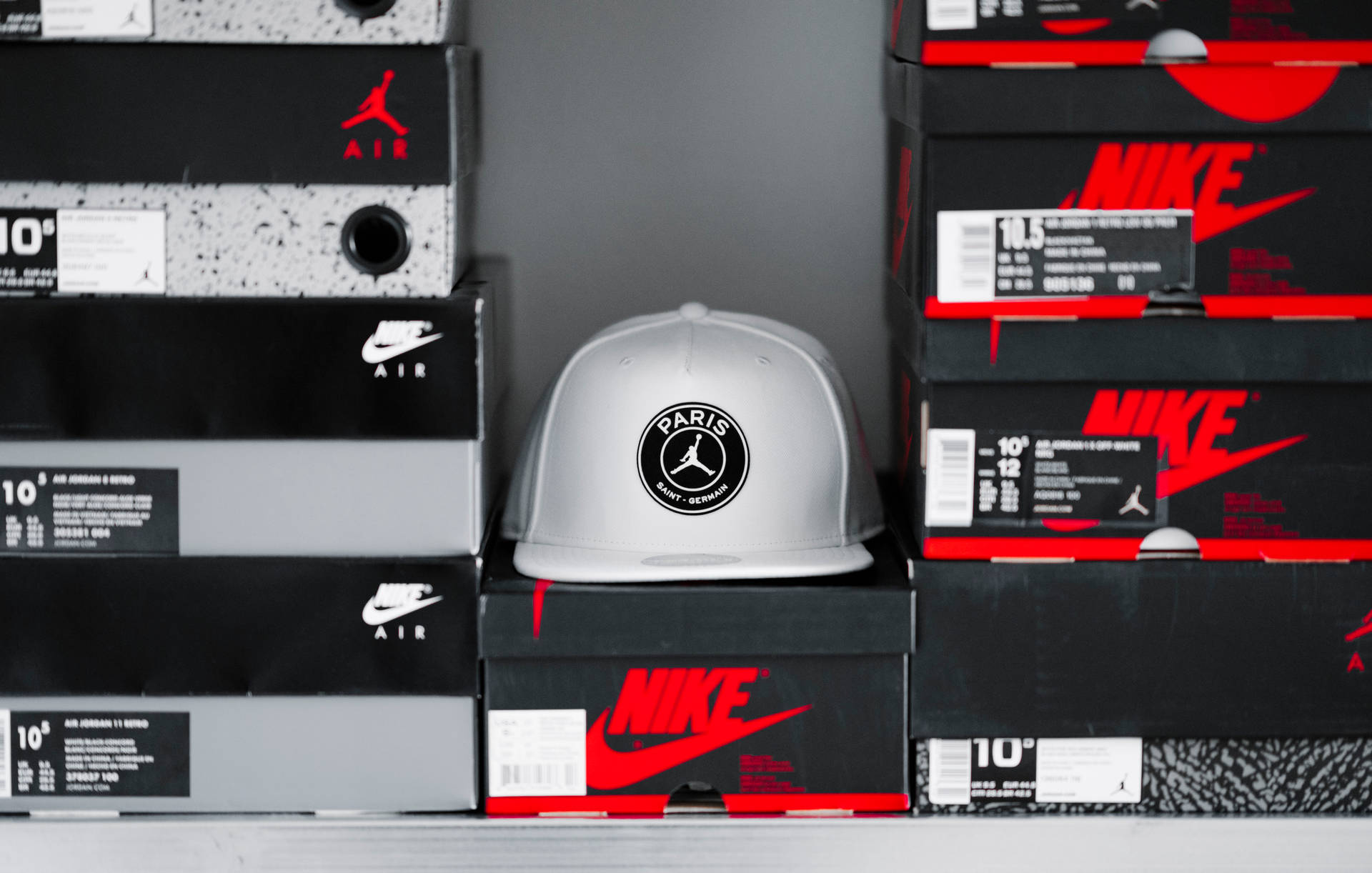銀色帽子帶有PSG標誌在Nike Air Jordan鞋盒上。