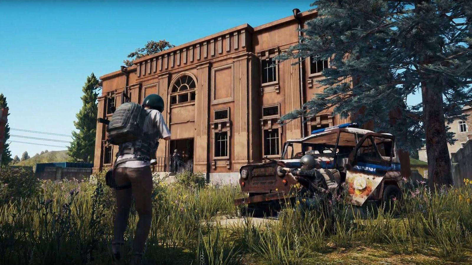 PUBG 3D 生動高清戰鬥中 壁紙 — 一名背著背包的士兵向一座風化的磚砌建築前進，另一名則蹲在生鏽的警車旁，周圍長滿了雜草。