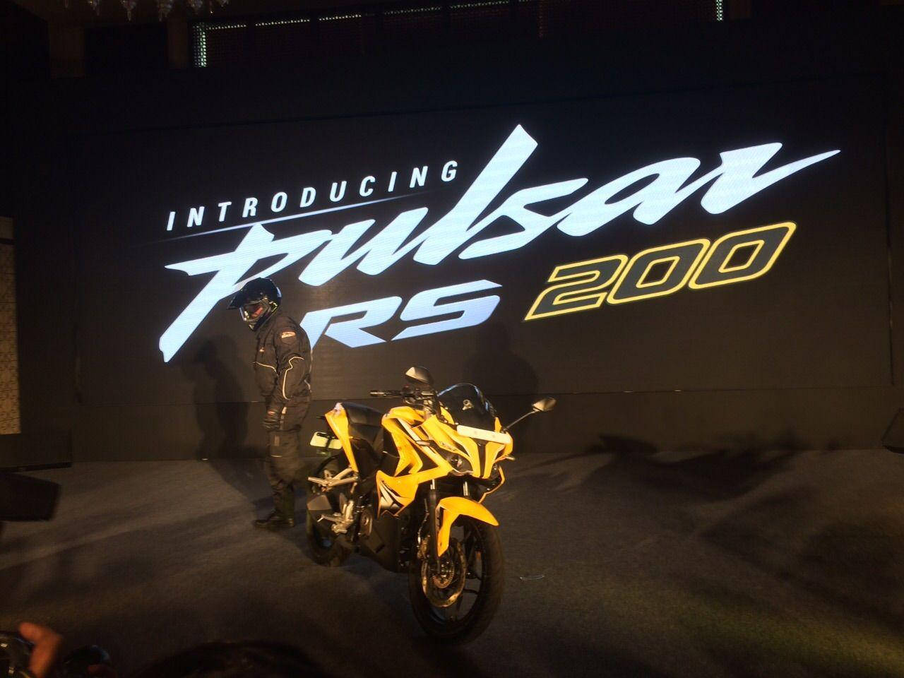 產品發佈活動中，黃色Pulsar RS 200電單車與騎手。
