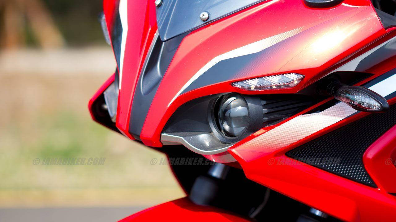 Pulsar RS200 鏡頭特寫 壁紙 — 紅色運動電單車嘅侵略性前整流罩近鏡，有尖銳線條同流線型頭燈。