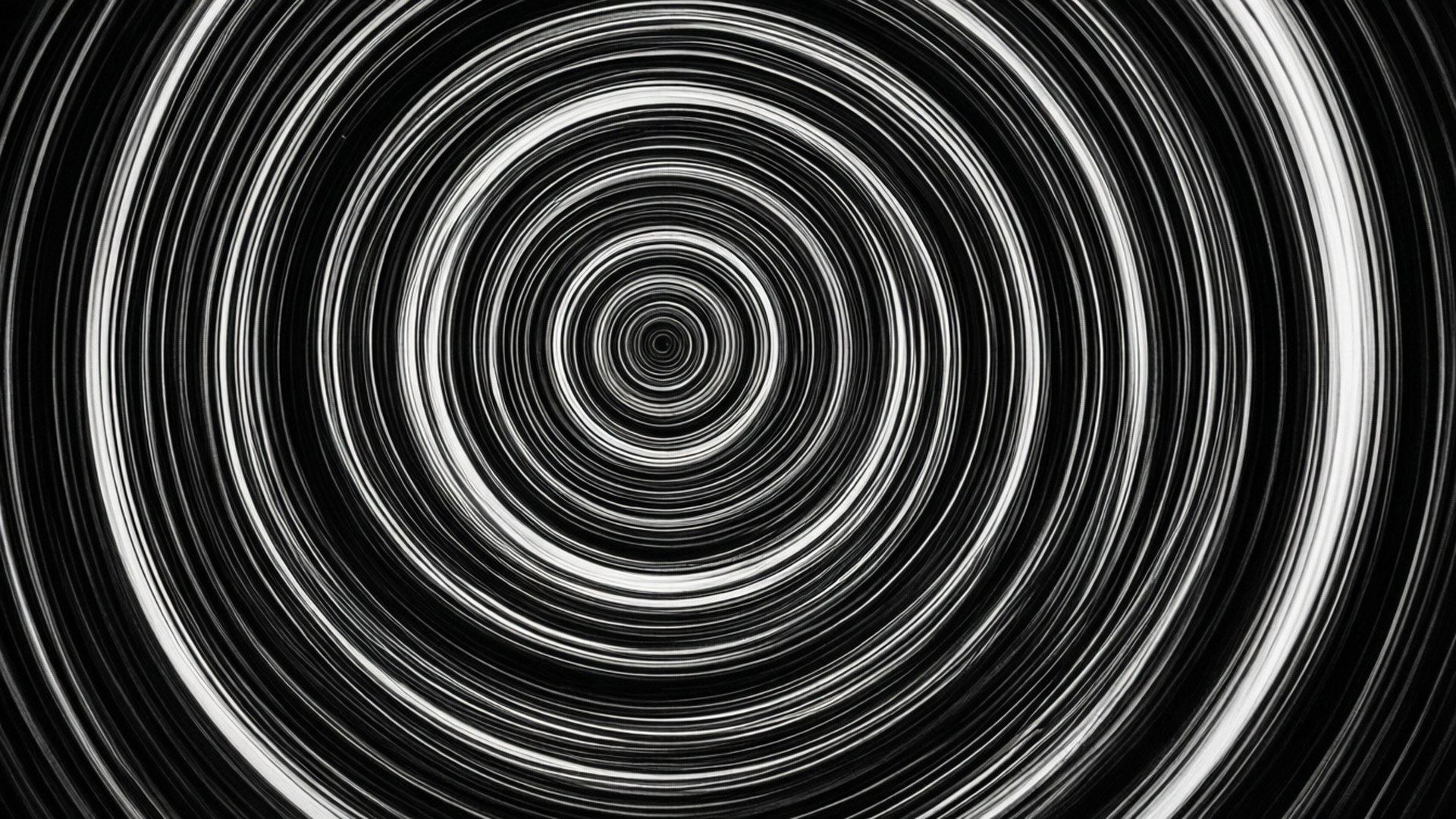 Pulsating Rings 壁紙 — 一個催眠的黑白螺旋圖案向內輻射，同心圓環創造出隧道效果。