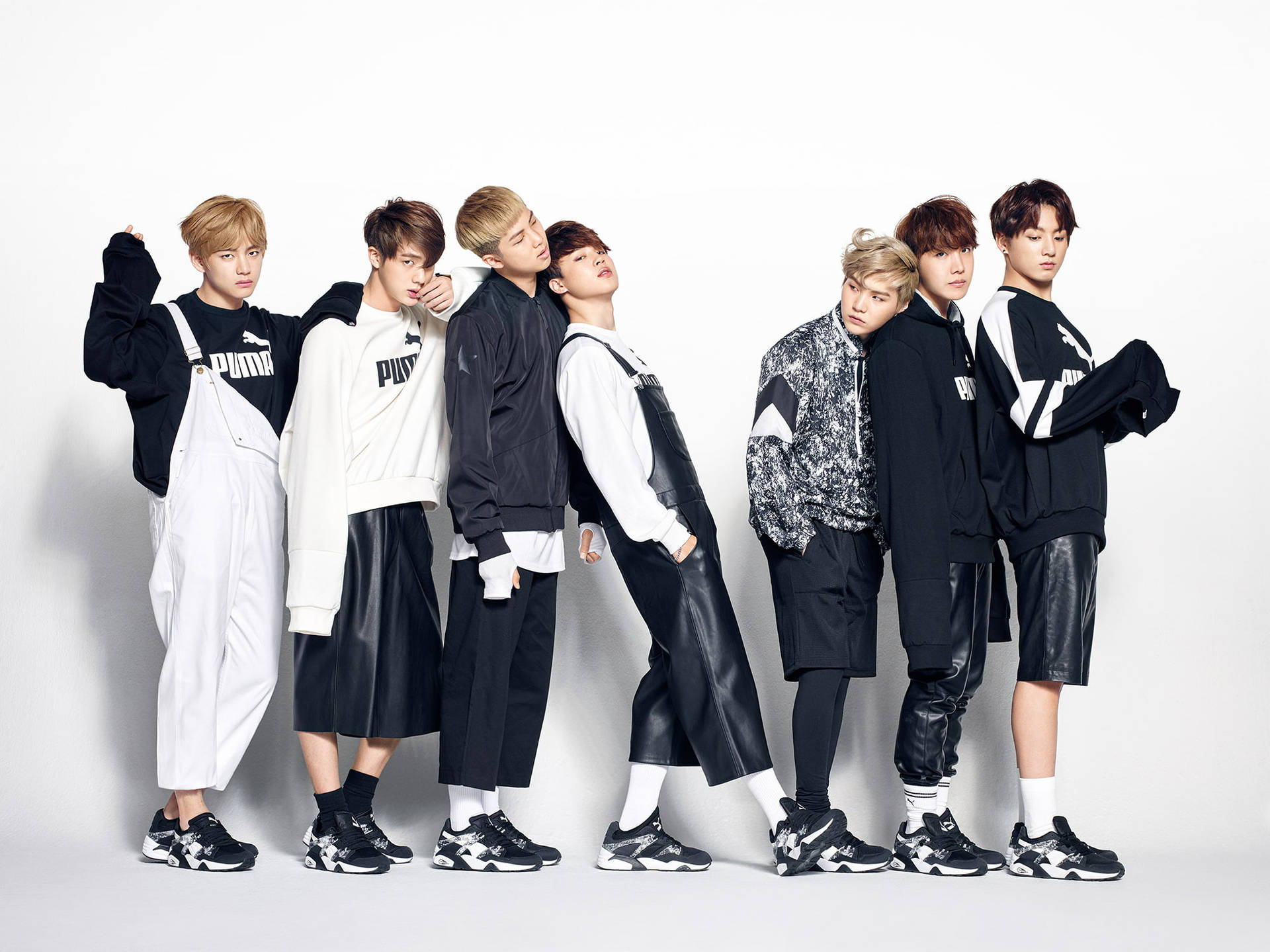 Puma酷BTS筆電壁紙 壁紙 — 七位時尚年輕男士身穿黑白Puma服裝，在純白工作室背景前自信擺姿勢。